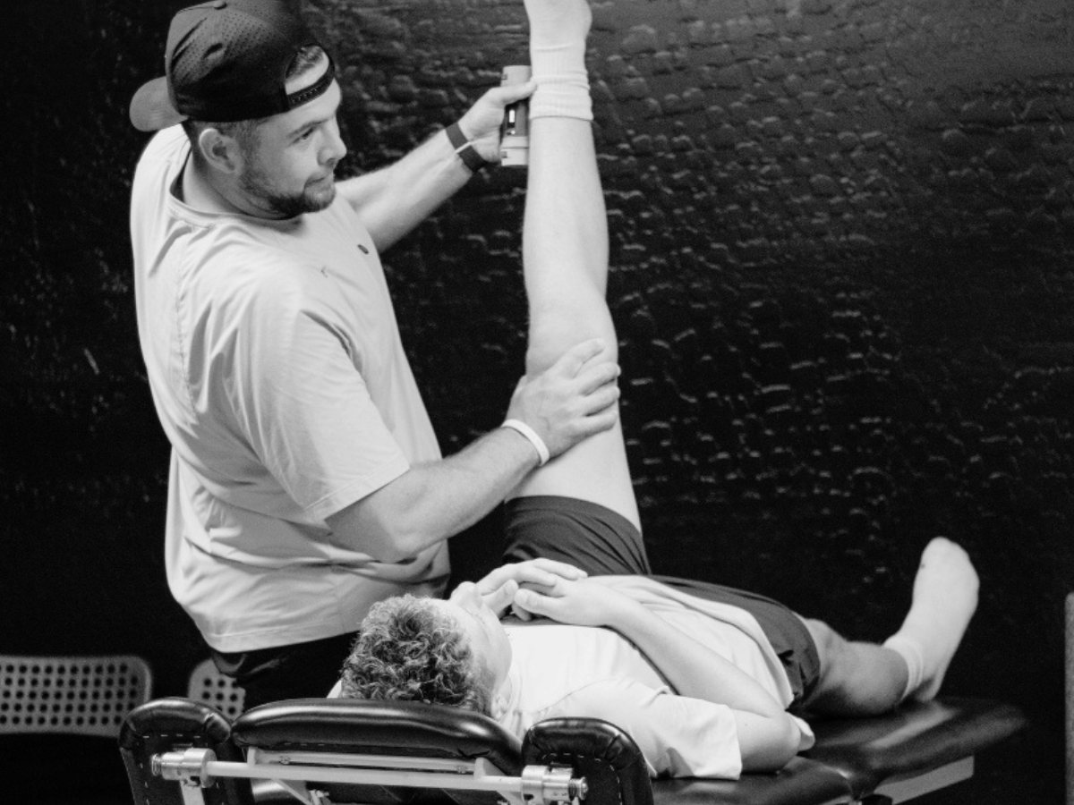 Dr. Keagan Barrett assessing an athlete during a one-on-one sports physical therapy session